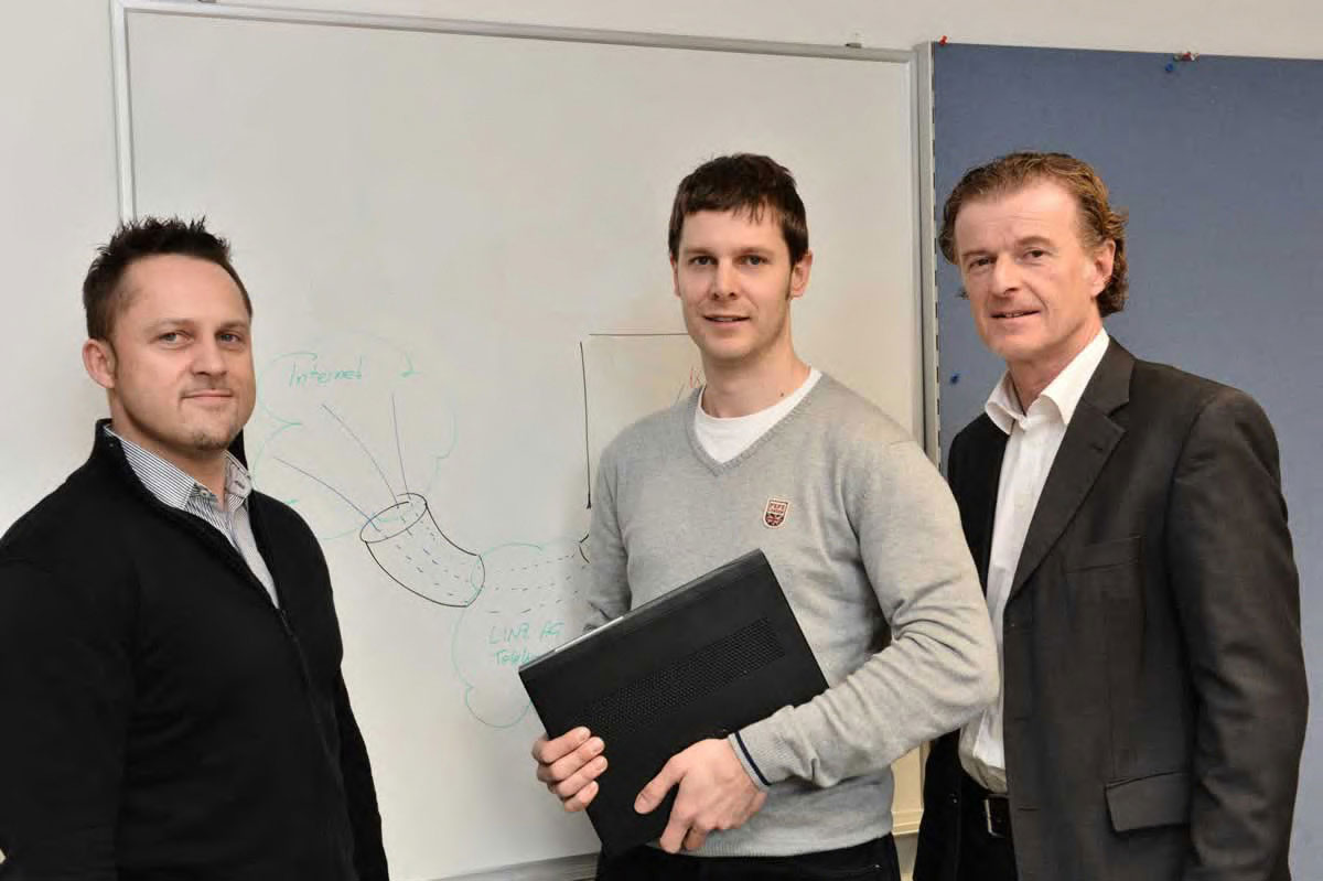 Drei Mitarbeiter von LINZ AG TELEKOM stehen gemeinsam vor einer Präsentationstafel.